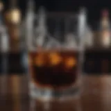 A close-up of a glass filled with dark liquid, condensation on the sides, set against a blurred background of a bar.